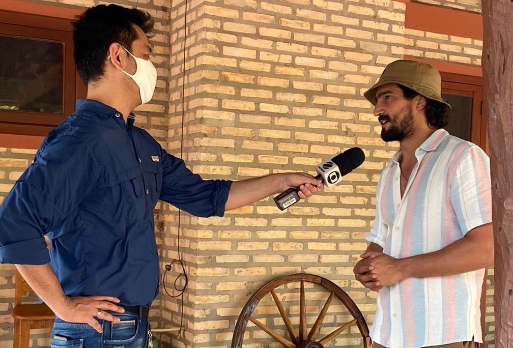 Repórter Alysson Maruyama entrevista o ator Renato Góes, que vai viver o personagem José Leôncio na primeira fase da trama — Foto: Ellen Rocha/TV Morena
