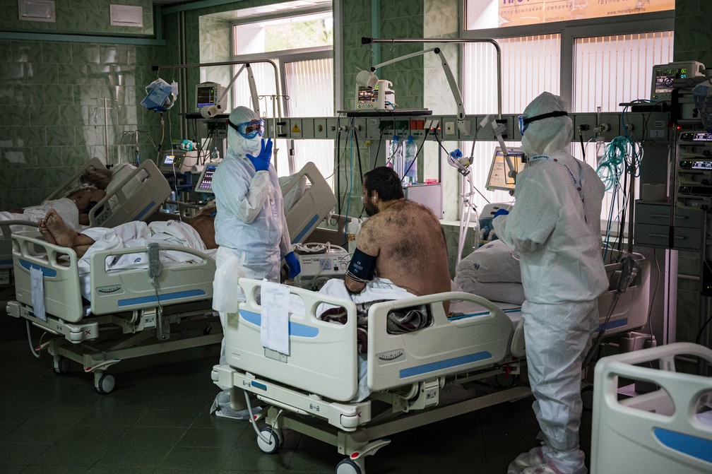 Funcionários do Hospital Clínico da Cidade Vinogradov, em Moscou, atendem paciente na  Unidade de Terapia Intensiva (UTI) no domingo (17)  — Foto: Dimitar Dilkoff / AFP