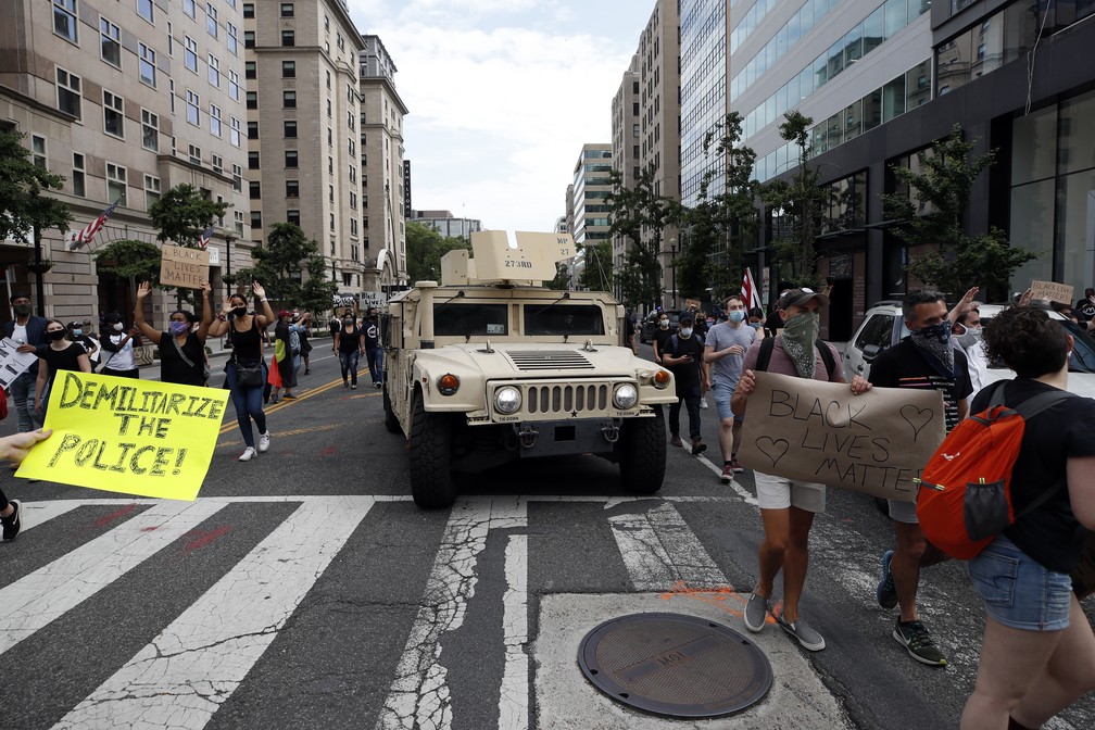 Veículo militar passa em Washington diante de manifestantes em protesto antirracista nesta terça (2) — Foto: Alex Brandon/AP Photo