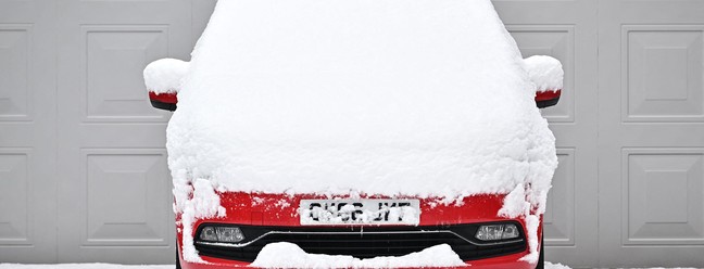 A neve cobre um carro estacionado em uma garagem em Brenchley, sudeste da Inglaterra — Foto: Ben Stansall / AFP