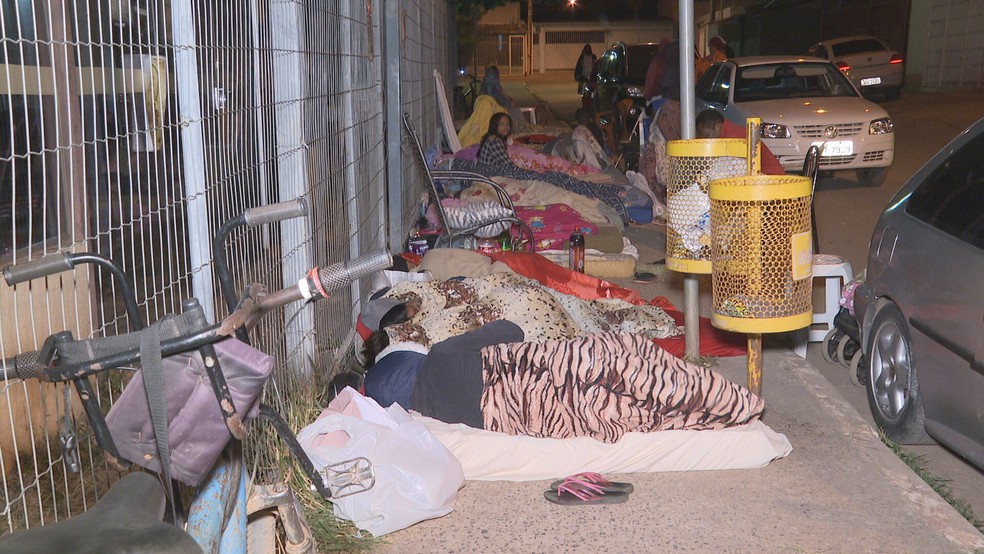 Pessoas dormem em frente à unidades do Cras para conseguir senhas de atendimento no dia seguinte — Foto: TV Globo/Reprodução
