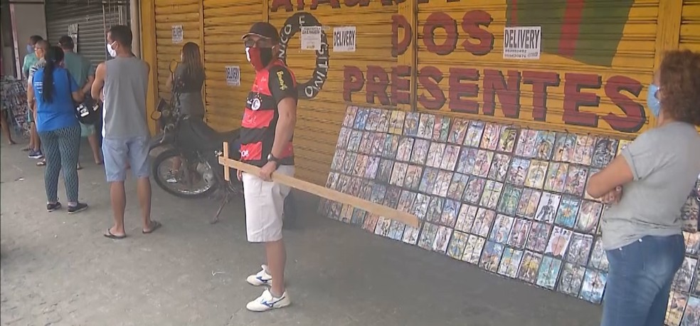 Pedagogo usa pedaço de madeira para manter distância em filas, em João Pessoa — Foto: TV Cabo Branco/Reprodução