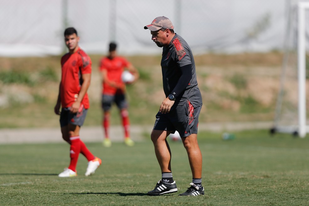 Com Daniel Cabral ao fundo, Fábio Matias dirige o Flamengo sub-20 na véspera da estreia no estadual — Foto: Gilvan de Souza/Flamengo