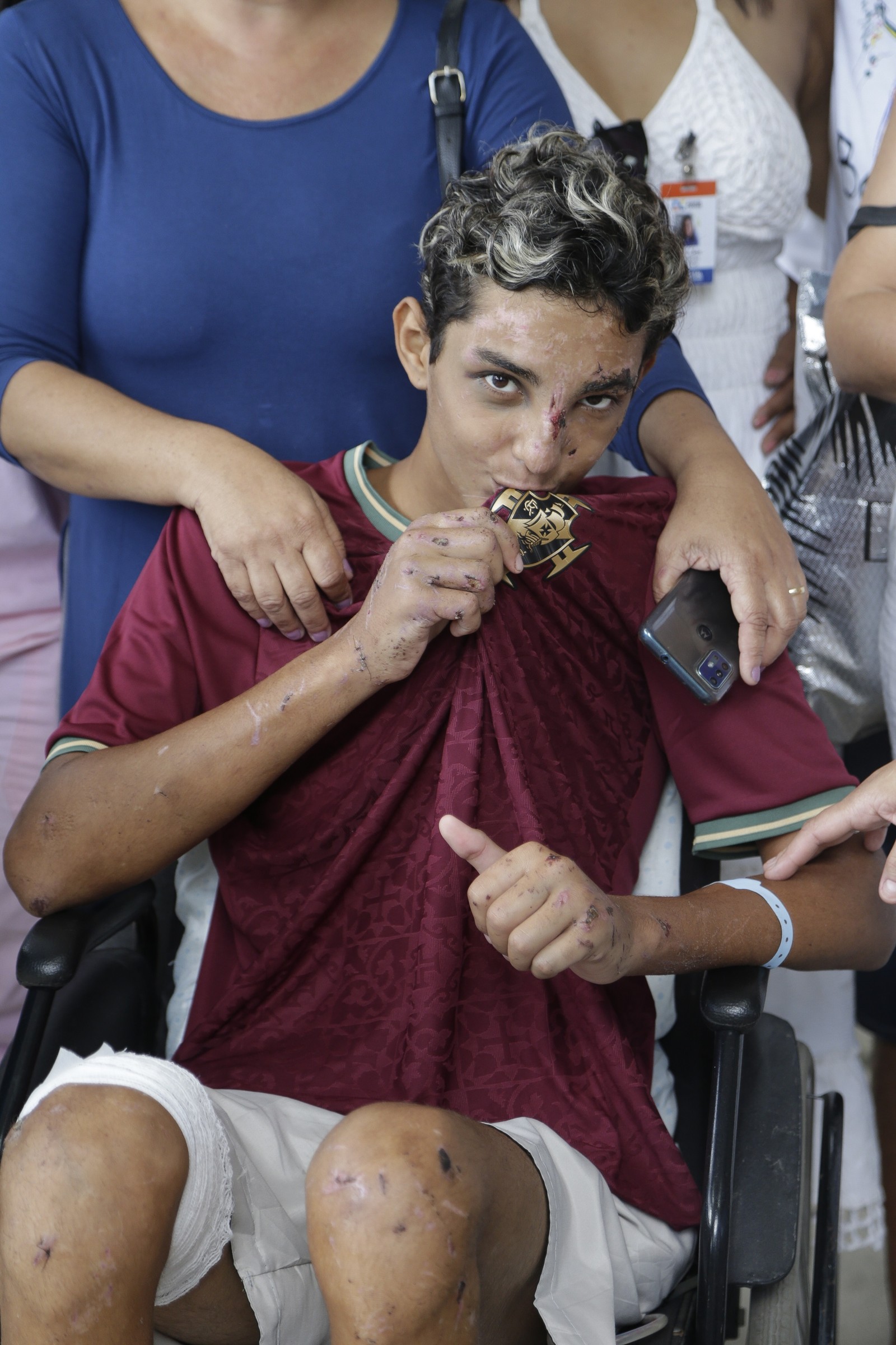 Com sonho de se tornar jogador de futebol, Christhian beija o escudo do Vasco na saída do hospital — Foto: Roberto Moreyra / Agência O Globo