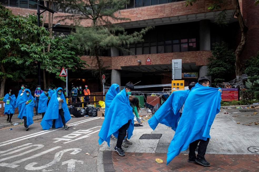 Manifestantes deixam a Universidade Politécnica de Hong Kong, no dia 19 de novembro de 2019 — Foto: Nicolas Asfouri / AFP
