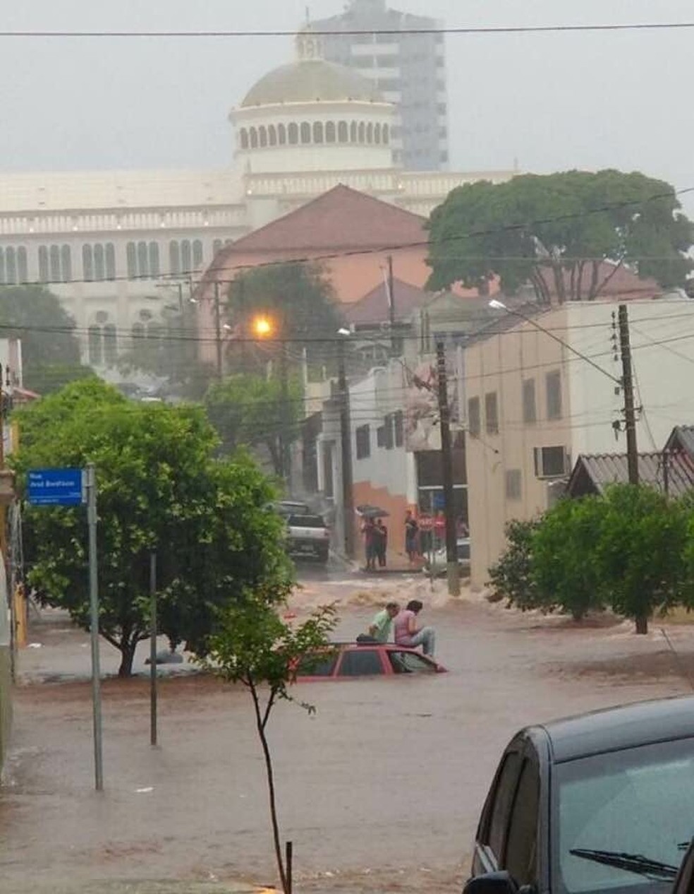 Carros ficaram parcialmente encobertos pela água de córrego que transbordou em Assis (Foto: Reprodução/TV TEM)
