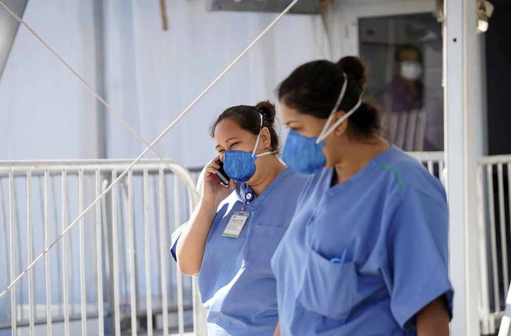 Enfermeiras caminham na entrada de um hospital do Rio de Janeiro, construído para o tratamento dos pacientes com Coronavírus-19 — Foto: Mauro Pimentel/AFP