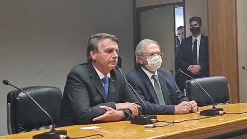 Bolsonaro e Paulo Guedes em pronunciamento nesta sexta; ministro afirmou que elevação do benefício 'não muda a filosofia de responsabilidade fiscal' (Foto: Reprodução/Facebook via BBC News)