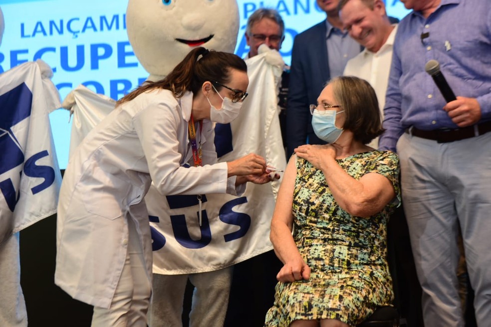 Marina Maria Fernandes de 74 anos foi a primeira pessoa a ser vacinada durante a cerimônia — Foto: Reprodução/Ricardo Medeiros