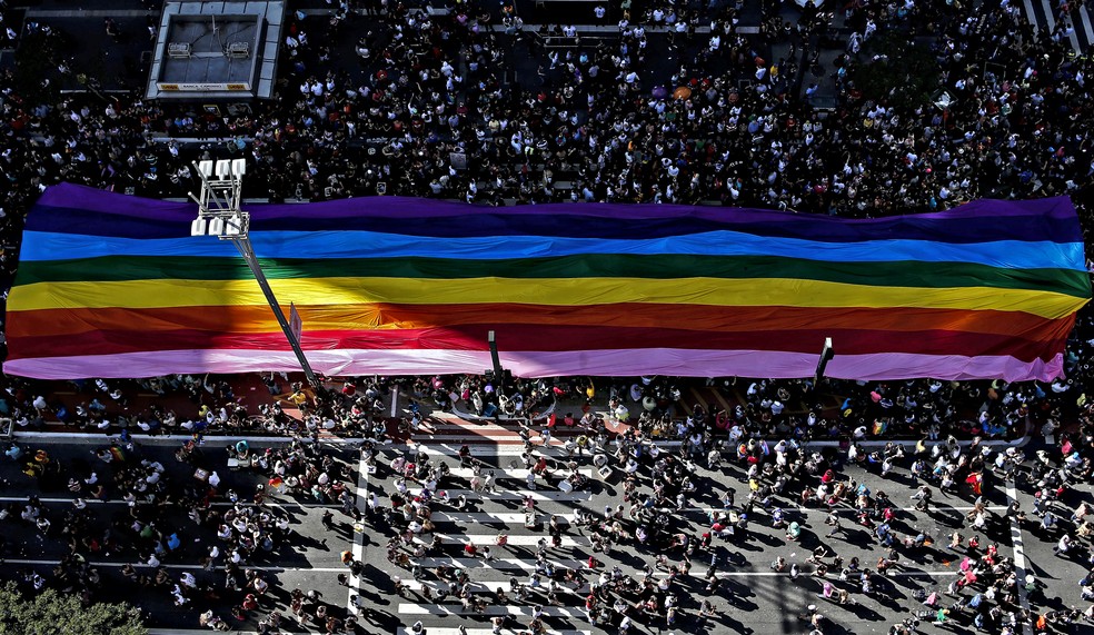 Bandeira do orgulho LGBT é carregada pela Avenida Paulista, em São Paulo, durante a Parada Gay — Foto: Miguel Schincariol/AFP