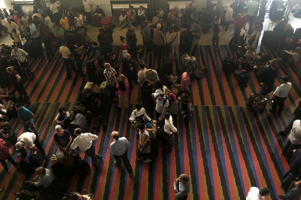 Passageiros no aeroporto de Simon Bolívar, na Venezuela, aglomeram-se em dia de apagão — Foto: Marco Bello/Reuters