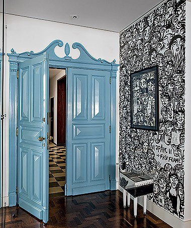 Entrada | Original do apartamento, a porta entalhada dos anos 1950 foi pintada de azul. Na parede, à dir., obras de Guilherme Kramer (Foto: Marco Antonio/Editora Globo)