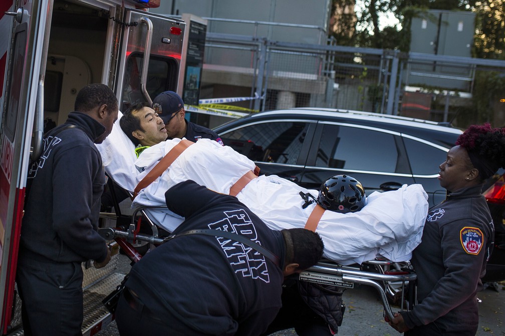 Homem Ã© levado para uma ambulÃ¢ncia apÃ³s ficar ferido em atentado em ciclovia nesta terÃ§a-feira, em Nova York (Foto: Andres Kudacki/AP)