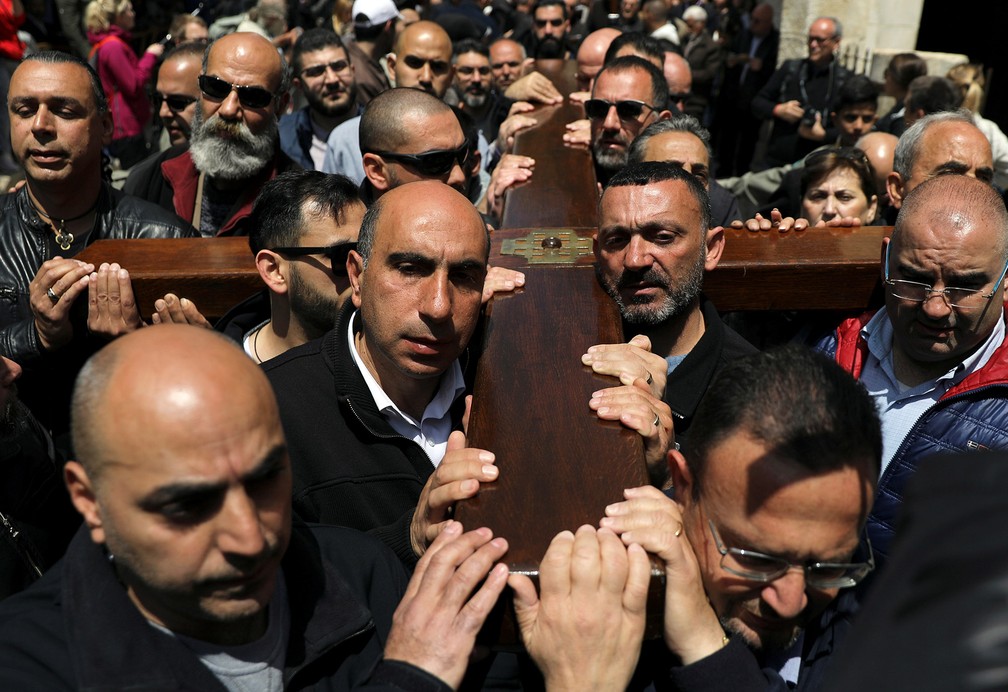 Devotos carregam uma cruz de madeira durante procissão de Sexta-Feira Santa na Via Dolorosa, na Cidade Velha de Jerusalém — Foto: Ammar Awad/Reuters