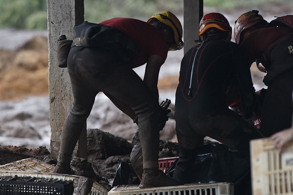 27 de janeiro  - Bombeiros retiram corpo da lama depois do rompimento da barragem da Vale em Brumadinho. — Foto: Leo Correa/AP