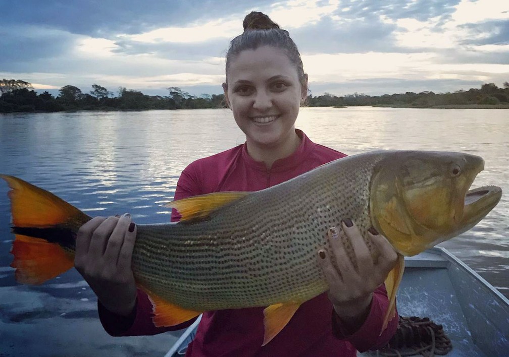 Andréia Gelain Cargnin posa com o maior de 11 dourados que ela e seu marido pescaram no Pantanal, em maio deste ano — Foto: Arquivo pessoal/Andréia Gelain Cargnin
