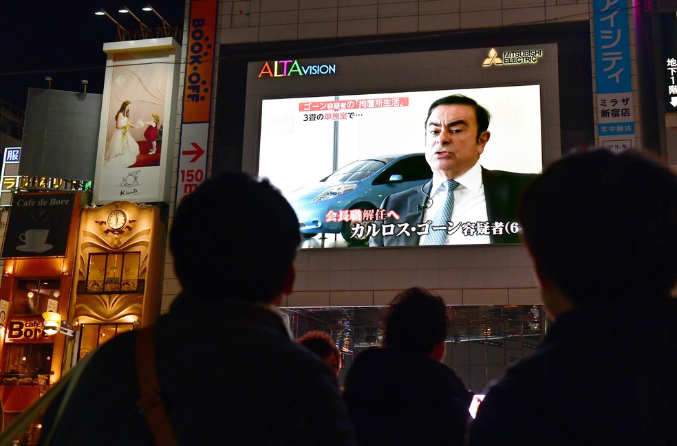 Japoneses assistem reportagem sobre Carlos Ghosn nas ruas de Tóquio nesta quinta-feira (22) — Foto: Kazuhiro Nogi / AFP