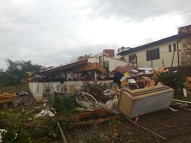 Casa atingida por temporal na noite de sábado teve mobília espalhada pelo terreno (Foto: Eveline Poncio/RBS TV)