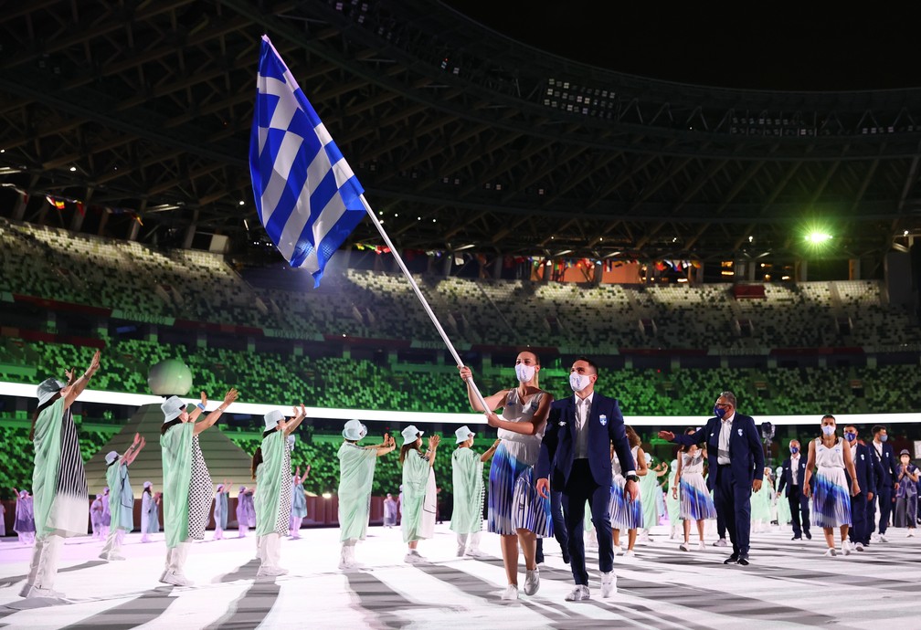  Eleftherios Petrounias e Anna Korakaki levam a bandeira da Grécia durante a cerimônia de abertura dos Jogos Olímpicos de Tóquio, no Japão — Foto: Kai Pfaffenbach/Reuters