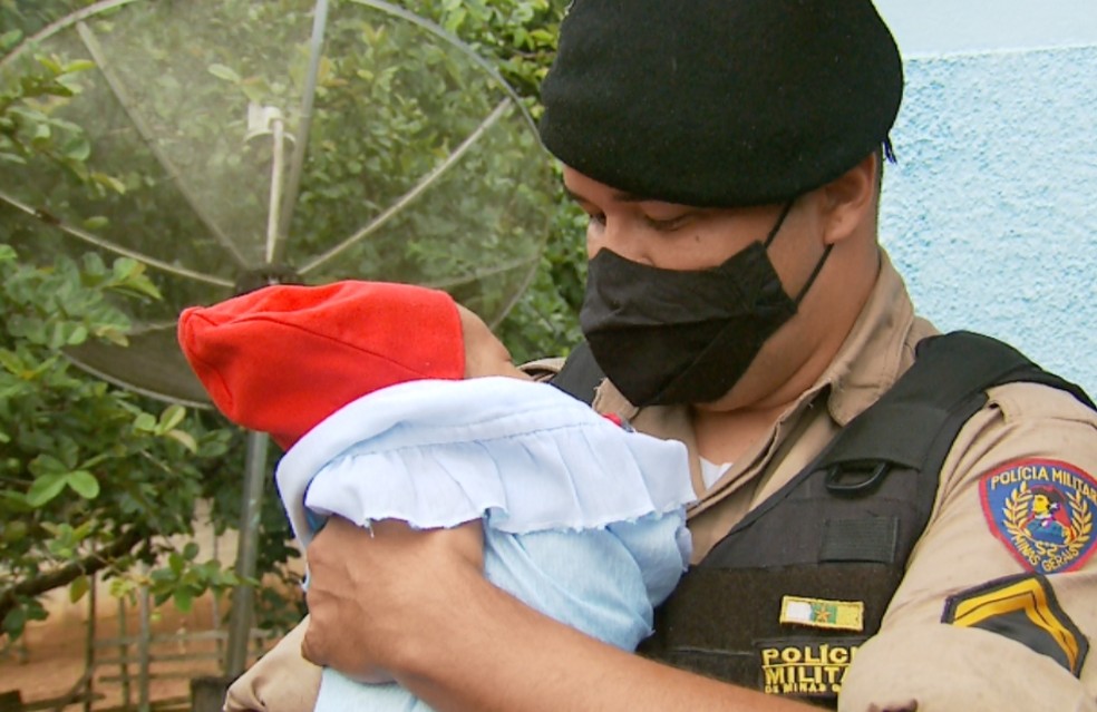 Cabo Elder Manoel e o bebê Emanuel, que foi salvo pela PM após engasgar durante amamentação em Paraguaçu (MG) — Foto: Erlei Peixoto/EPTV 