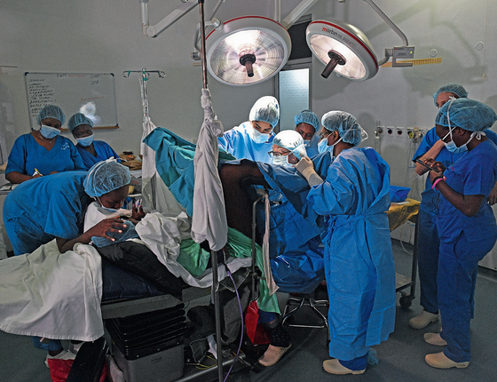 Marci Bowers numa cirurgia no Quênia,com profissionais locais (Foto: CARL DE SOUZA/AFP)