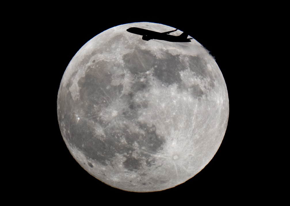 Alemanha: uma aeronave é fotografada diante da lua cheia em Frankfurt neste domingo, 15 — Foto: Michael Probst/AP