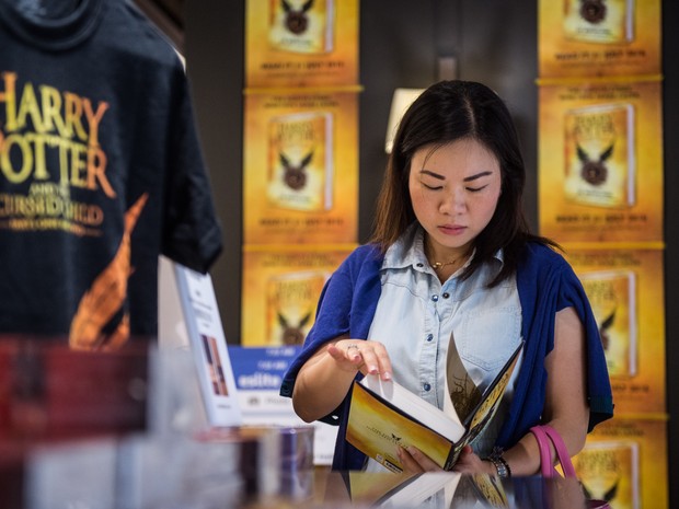 Garota lê cópia logo após o lançamento em livraria de Hong Kong (Foto: ANTHONY WALLACE / AFP)
