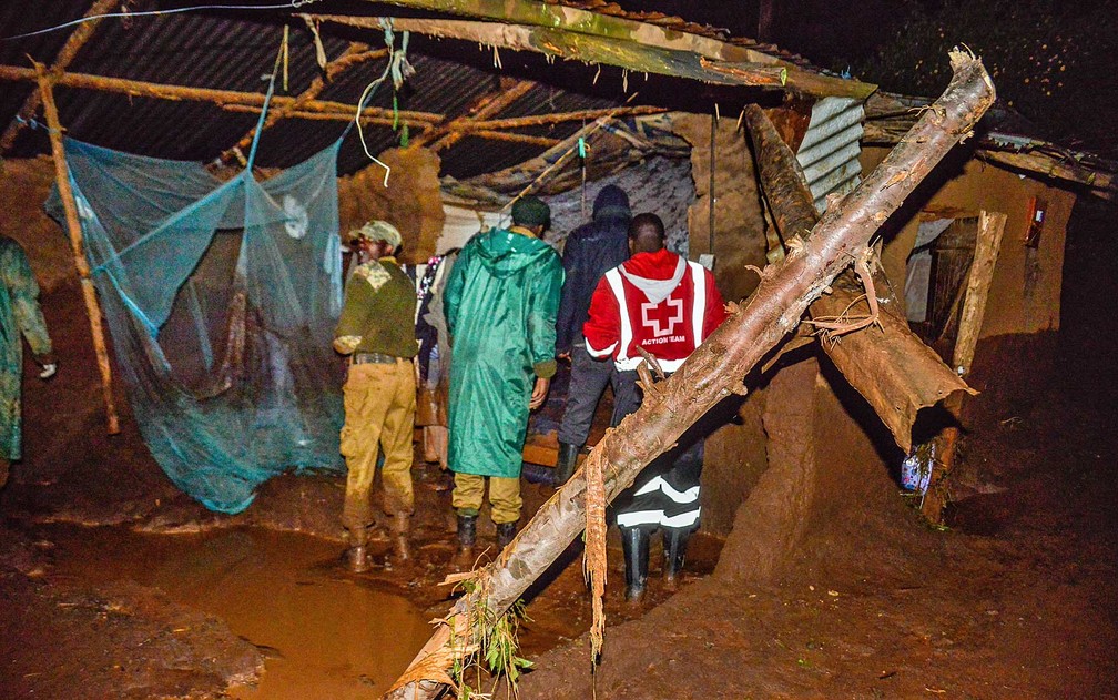 Voluntários procuram sobreviventes em uma área residencial depois que represa de Solai ruiu (Foto: AFP Photo)