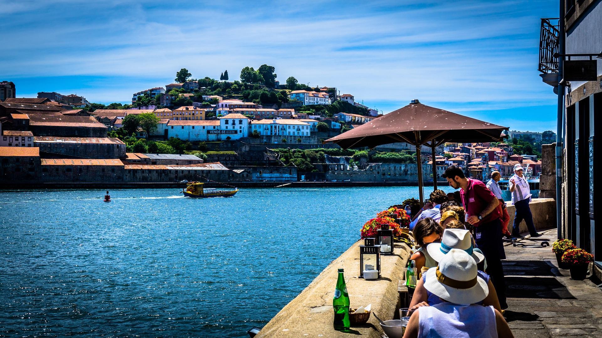 Garçom serve clientes em mesas à beira do Rio Douro, no Porto, em foto de arquivo
