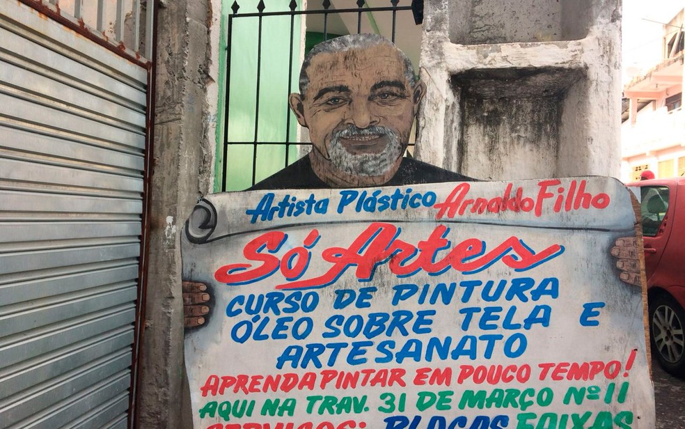 Auto-retrato feito por Nadinho, para divulgar o pr&oacute;prio trabalho, na entrada da rua onde morava em Candeias (Foto: Juliana Almirante/G1)
