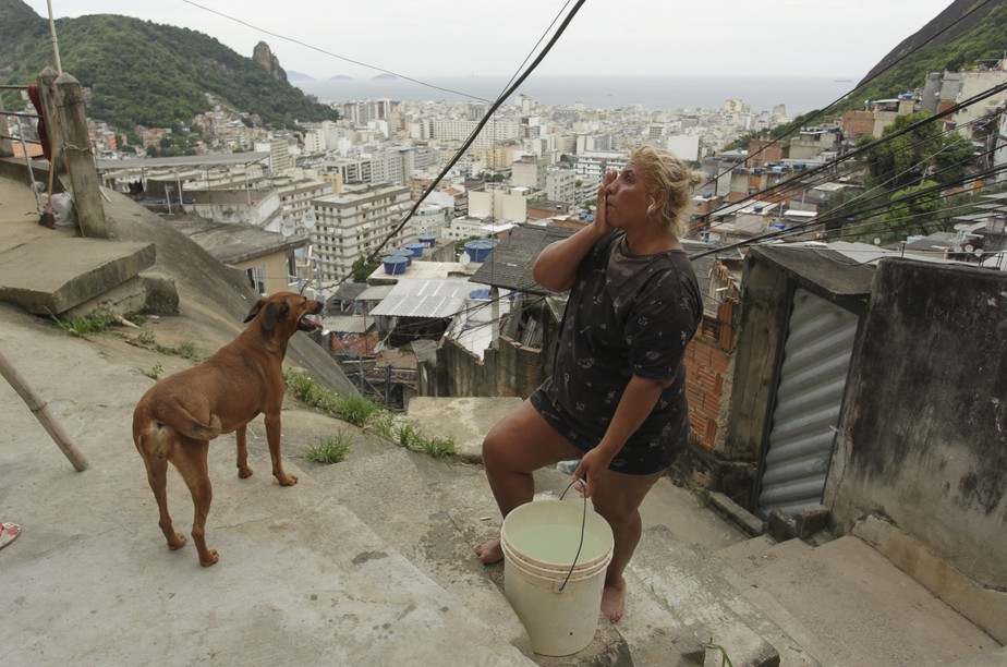 Moradora do Morro dos Cabritos, na Zona Sul do Rio, carrega um balde d'àgua