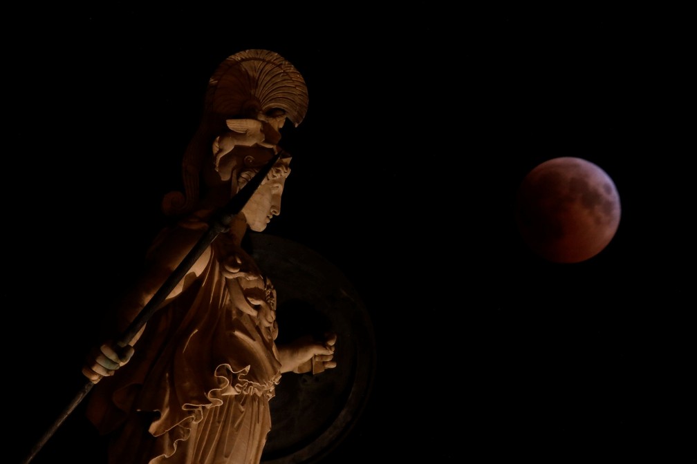 Lua de sangue durante eclipse; na imagem, estátua de Athena na Grécia. (Foto: Costas Baltas/Reuters)