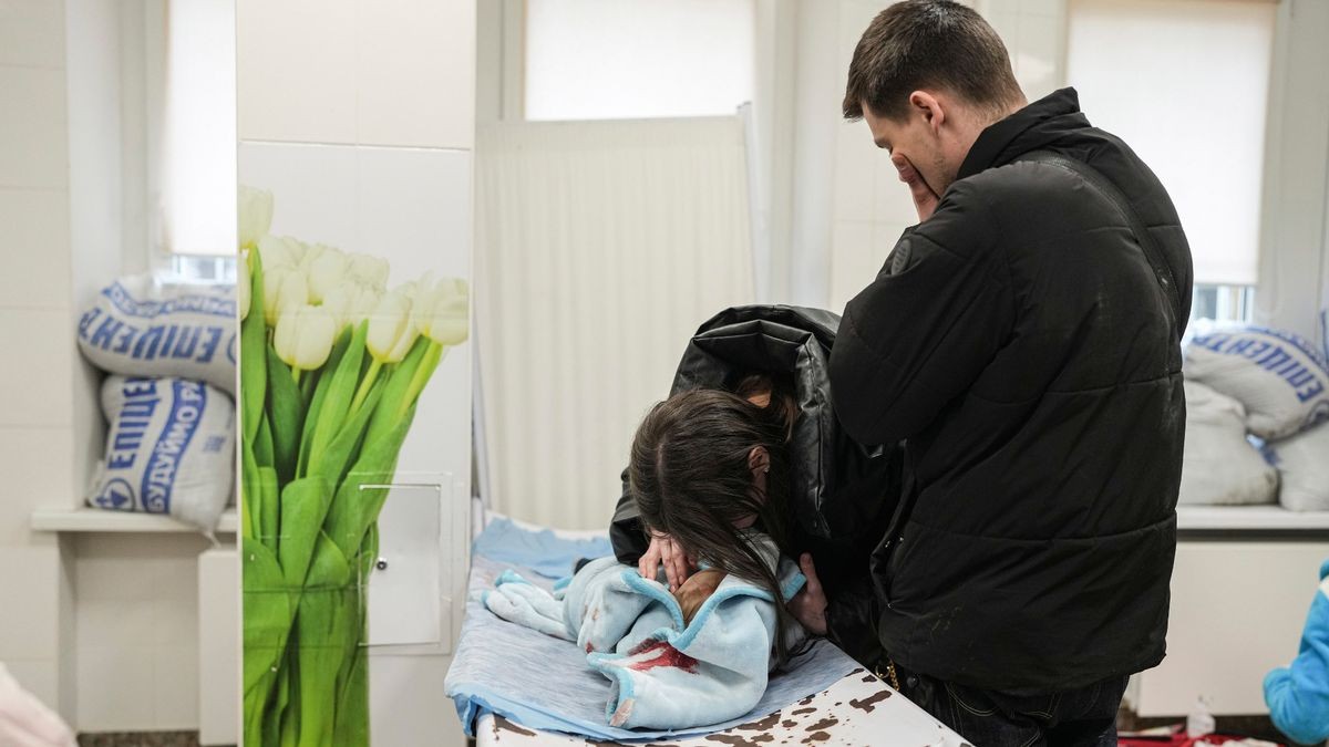 Pais choram em frente ao corpo do filho de 18 meses, na Ucrânia (Foto: Reprodução/Mirror)