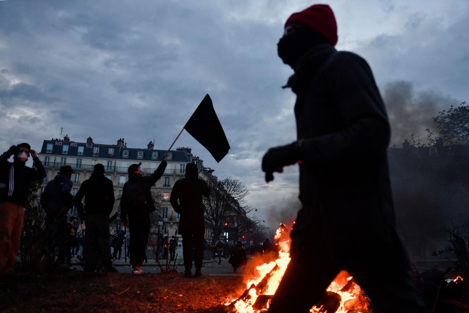 Manifestante passa por patinetes em chamas durante protesto em Paris, em 28 de março de 2023 — Foto: JULIEN DE ROSA / AFP
