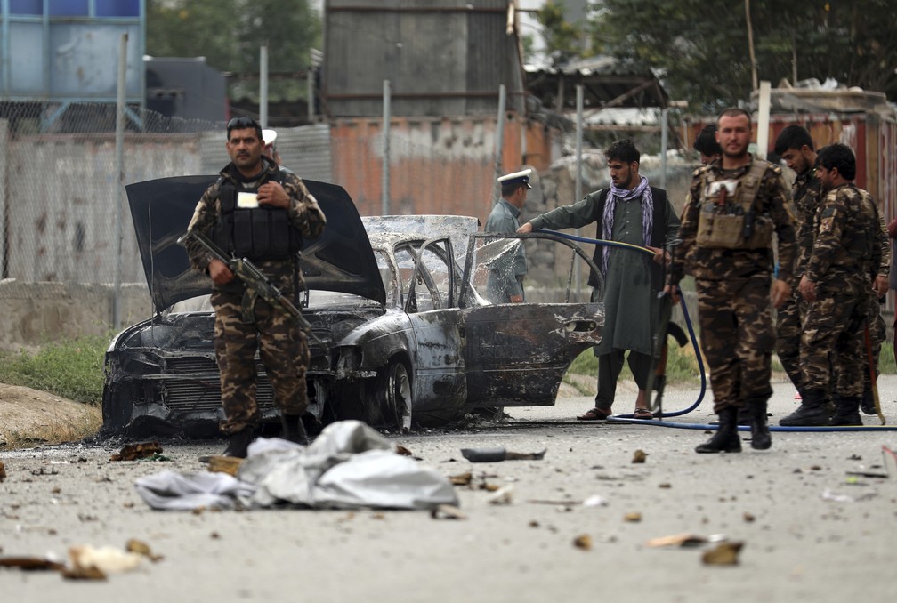 Forças de segurança inspecionam veículo danificado por foguete perto do palácio presidencial em Cabul, no Afeganistão, em 20 de julho de 2021 — Foto: Rahmat Gul/AP