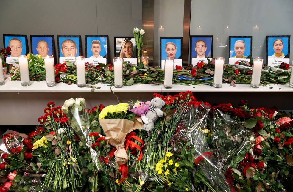 Flores e velas foram colocadas em frente às fotos da tripulação do avião ucraniano que caiu logo após decolar de Teerã, no Irã, nesta quarta (8). Nenhuma das 176 pessoas que estavam a bordo sobreviveu ao acidente. — Foto: Valentyn Ogirenko/Reuters