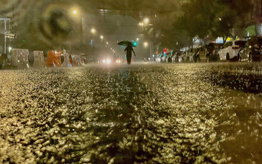 Pessoa caminha sob chuva no bairro do Bronx, em Nova York — Foto: David Dee Delgado/Getty Images/AFP