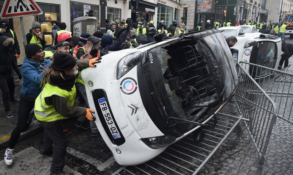 Manifestantes destroem carros durante um protesto em Paris, neste sábado (1º)  — Foto: Lucas Barioulet / AFP