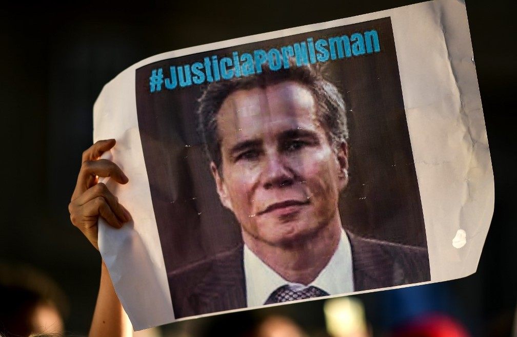 Manifestante ergue em Buenos Aires neste sábado (18) cartaz que pede 'Justiça por [Alberto] Nisman', morto em 2015 — Foto: Ronaldo Schemidt/AFP
