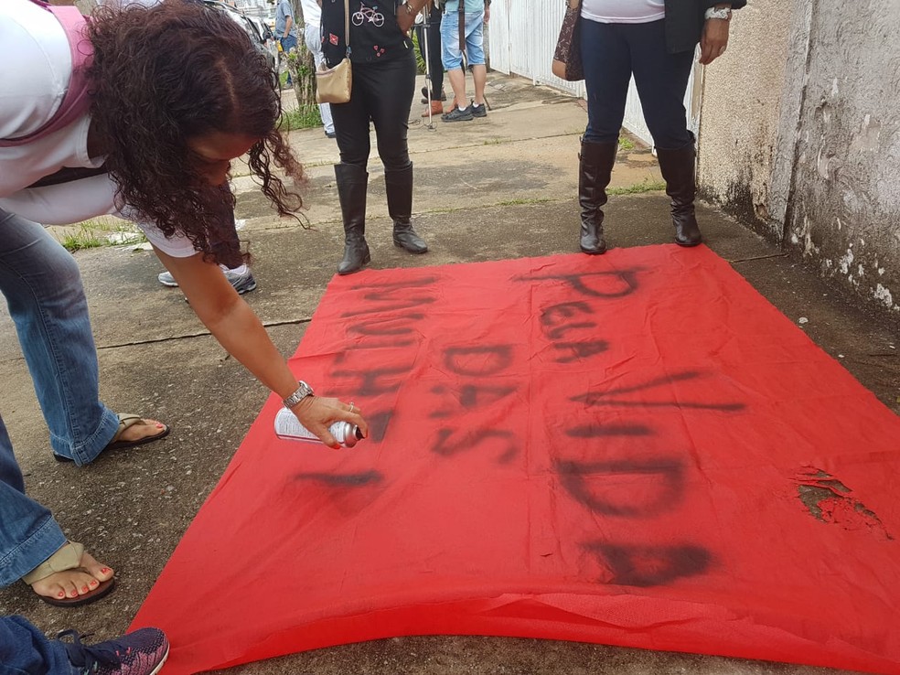 Manifestante produz faixa para protesto na inauguração do serviço 24 horas da Delegacia de Defesa da Mulher em Campinas (SP) — Foto: Luciano Calafiori/G1