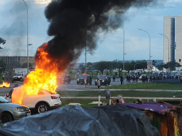 Um carro em chamas é visto durante um protesto na Esplanada dos Ministérios, em Brasília, contra a PEC 55, que limita os gastos públicos para os próximos 20 anos (Foto: Andressa Anholete/AFP)