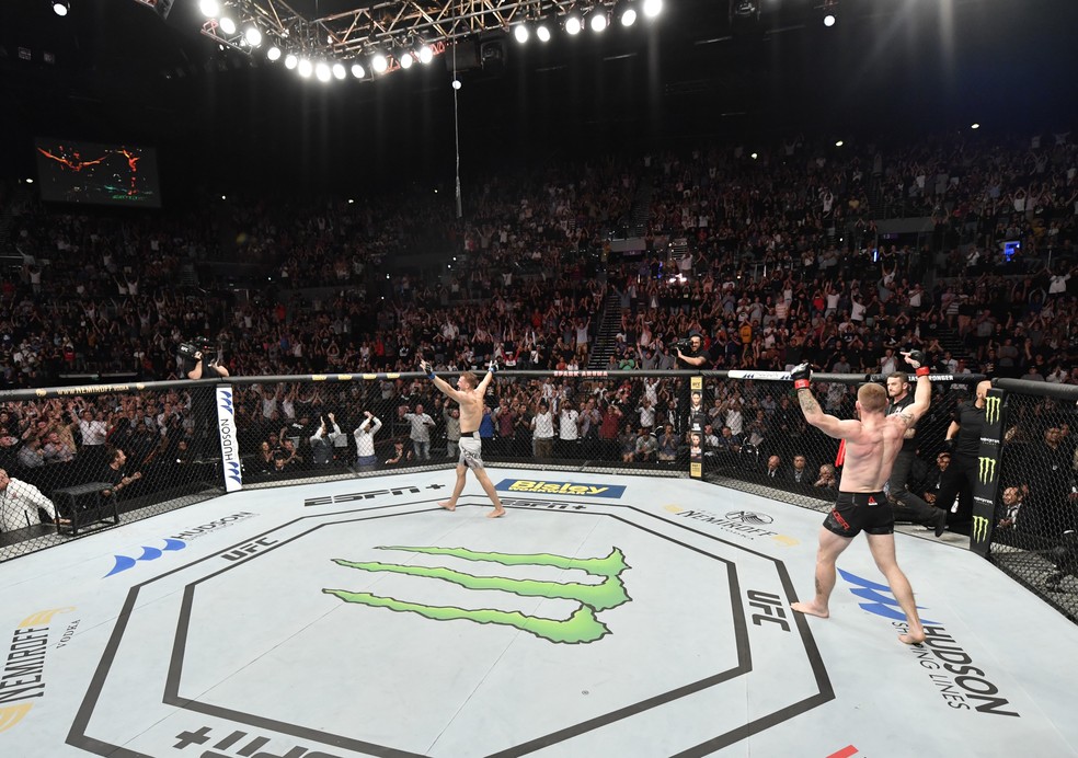 Paul Felder e Dan Hooker erguem os braços após o fim do quinto round no UFC Auckland — Foto: Getty Images