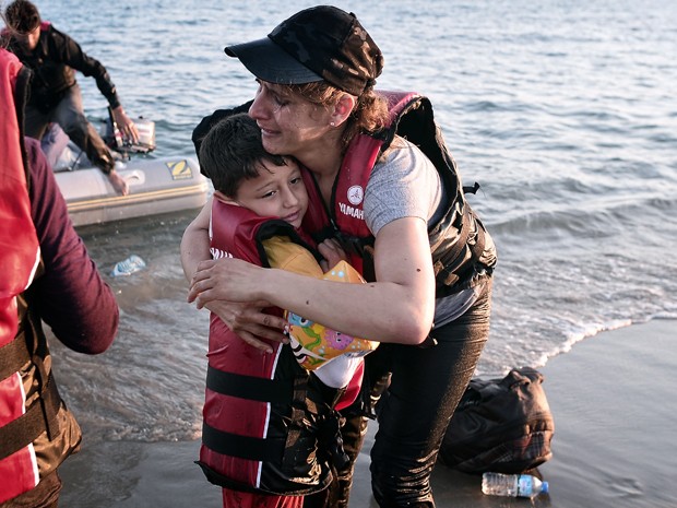 Imigrante chora e abraça seu filho ao chegarem em segurança à praia na ilha grega de Kos, na terça (18) (Foto: AFP Photo/Louisa Gouliamaki)