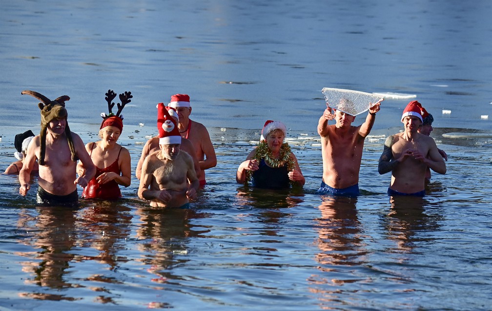 Em Berlim, nadadores de um clube fazem o tradicional mergulho de Natal no lago Orankesee, neste sábado (25) — Foto: Tobias Schwarz/AFP