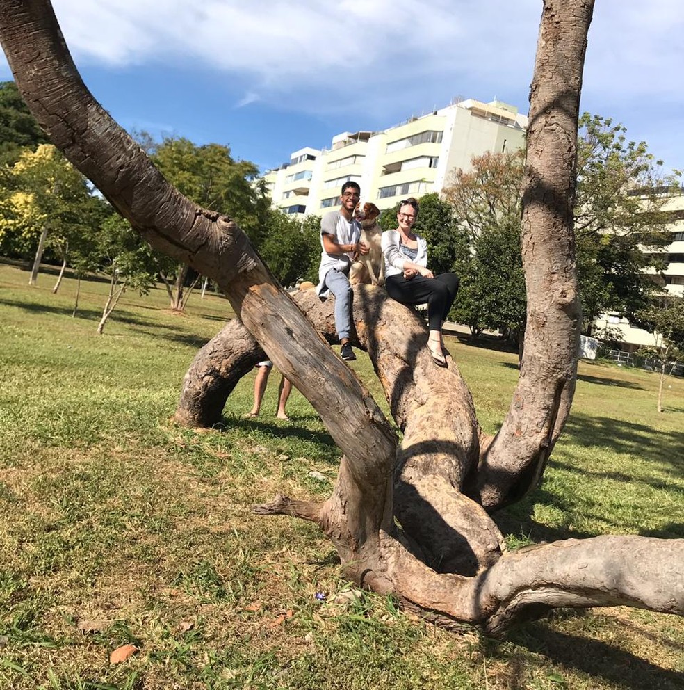 Moradores de Brasília com o cachorro em cima da árvore favorita na cidade — Foto: Delma/Arquivo pessoal