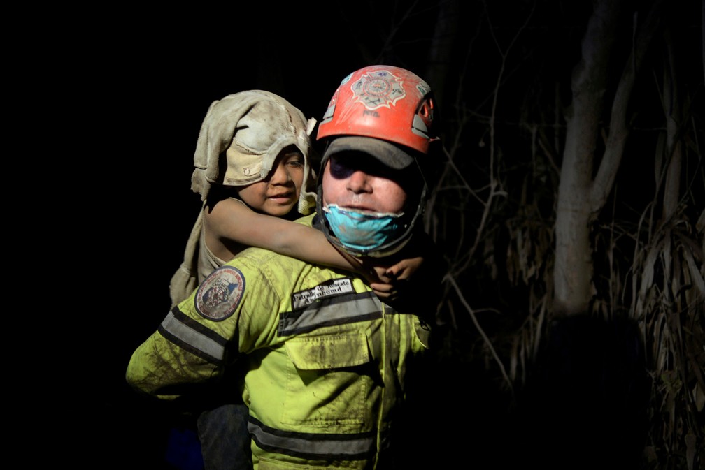 CrianÃ§a coberta de cinzas Ã© socorrida em El Rodeo, apÃ³s a erupÃ§Ã£o de vulcÃ£o de Fogo, na Guatemala, no domingo (3)  (Foto: Fabricio Alonzo/ Reuters)