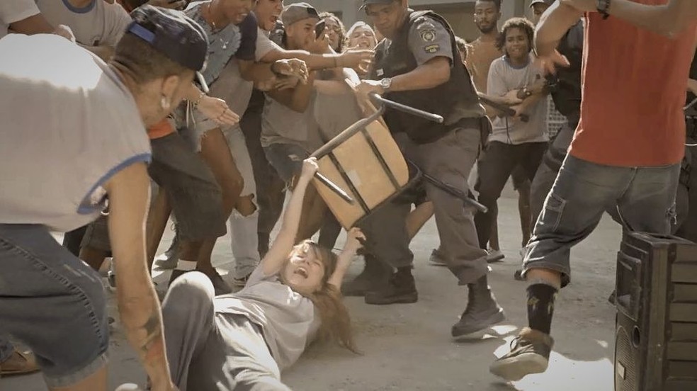 No meio da confusão, Joana (Cacá Ottoni) cai no chão e é arrastada pela polícia — Foto: Globo