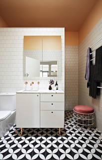 No banheiro deste sobrado na Austrália, o tom sofisticado de pêssego vai do teto até o início da parede de azulejos