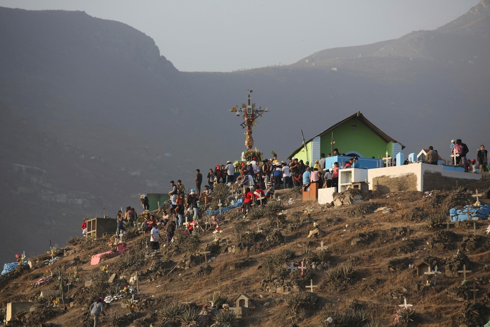 Pessoas caminham durante as celebrações do Dia dos Mortos no cemitério Nueva Esperanza em Lima, no Peru, nesta sexta (1º) — Foto: Martin Mejia/AP