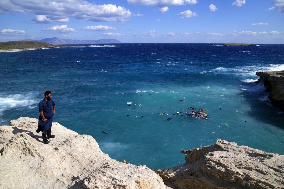 Em imagem de 6 de outubro, morador da ilha de Kythira, no sul da Grécia, observa um grupo de migrantes nadando após o bote em que estavam estourar. — Foto: Thanassis Stavrakis/ AP